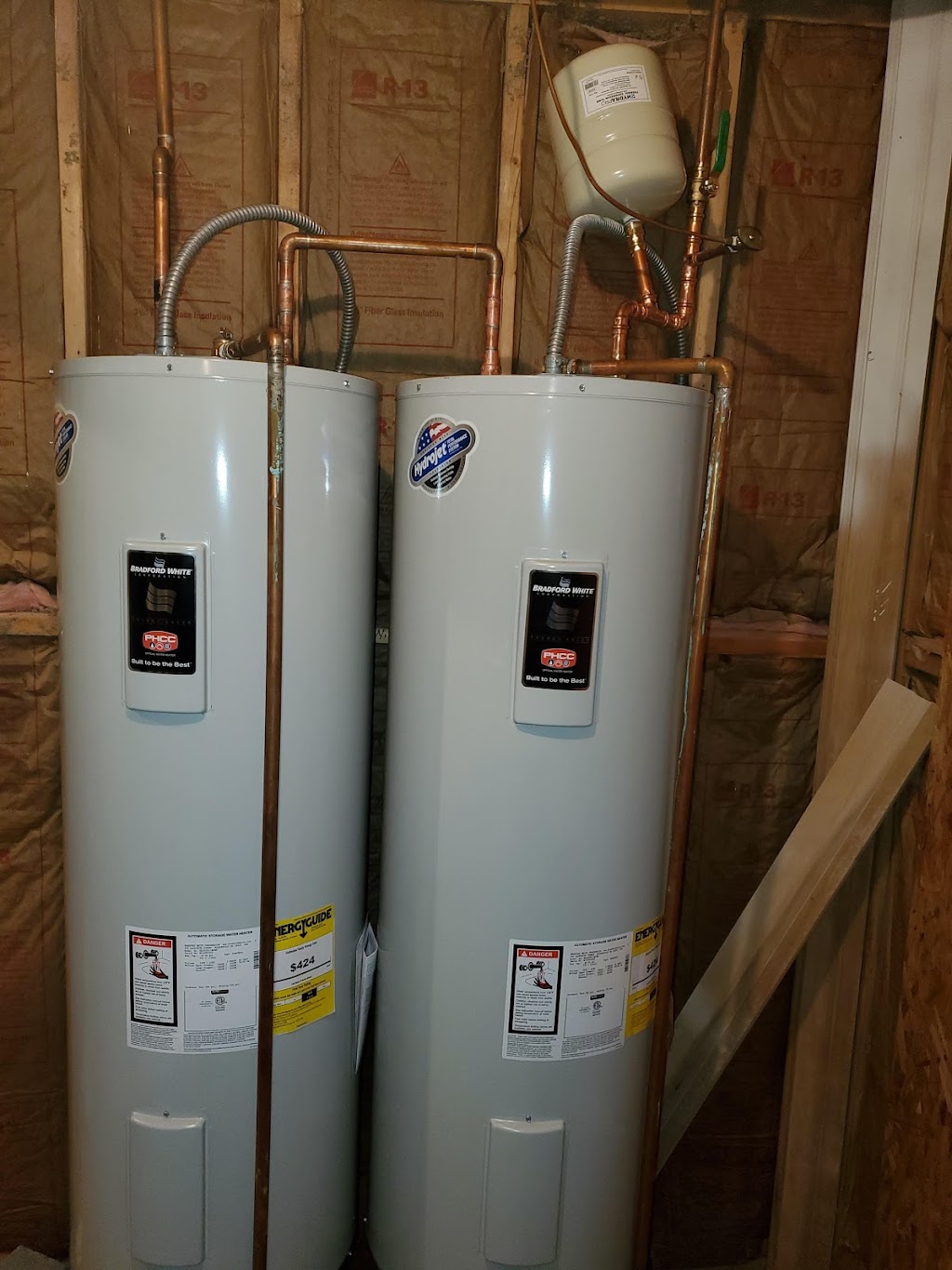 Bravo Plumbing Solutions — two Bradford White electric water heaters plumbed in copper with flex inlets and expansion tank