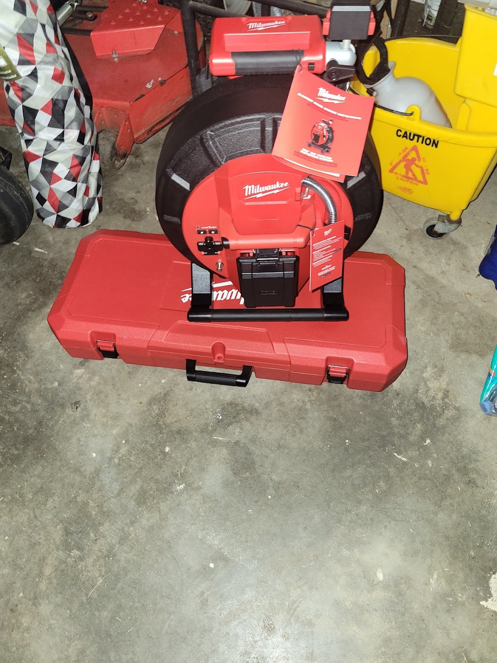 Bravo Plumbing Solutions — Milwaukee M18 sectional drain-cleaning machine staged on its hard case in the shop